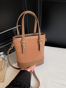 Retro brown contrast color bucket bag with suede and leather textures for elegant commuting