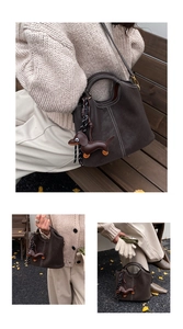 Detail einer dunkelbraunen Beuteltasche mit Kontrastnähten und einem Dackel-Anhänger