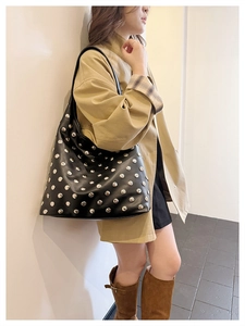 Détail du sac hobo noir avec des rivets argentés et une texture en cuir mat raffiné