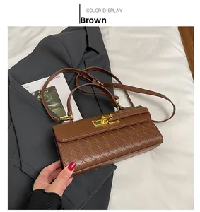 Dettaglio della borsa a mano intrecciata marrone con chiusura girevole dorata e tracolla
