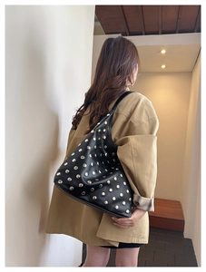 Gros plan sur le sac sous le bras noir vintage avec rivets métalliques argentés élégants