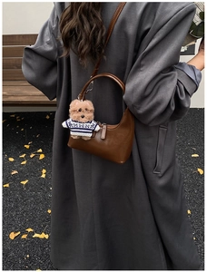 Détail du sac hobo marron foncé avec pendentif ours en peluche et bandoulière réglable