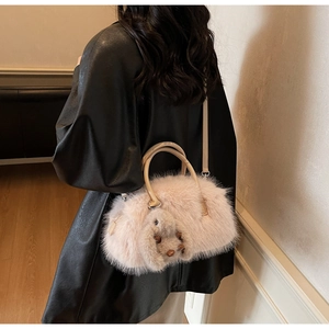 Detail of pink faux fur shell bag with plush rabbit charm and PU leather strap