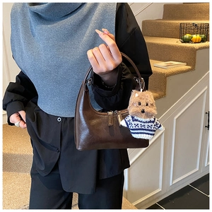 Détail du sac à main vintage marron foncé avec un charmant porte-clés ours en peluche