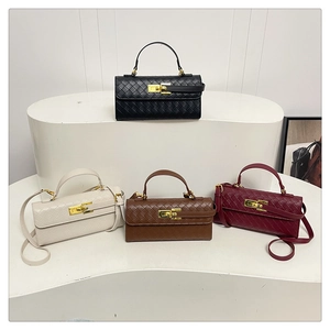 Dettaglio di borse in pelle intrecciata nei colori nero, crema, marrone e bordeaux con fibbie