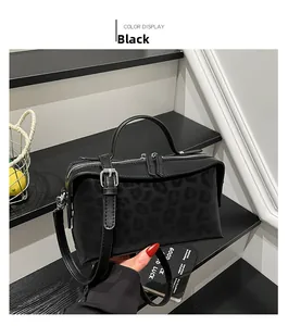 Detail of black leopard print shoulder bag with silver zipper and matte finish texture