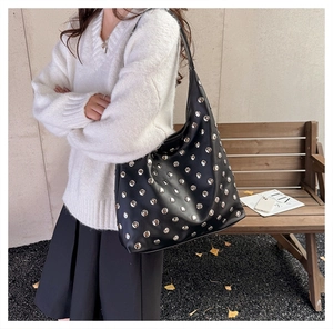 Détail d'un sac porté épaule hobo noir avec rivets métalliques argentés en extérieur