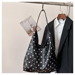 Détail d'un sac hobo en cuir noir orné de rivets argentés au style punk moderne