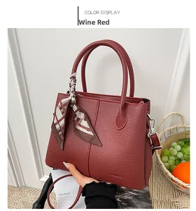 Detail of wine red large tote bag with silk scarf on handle and removable strap