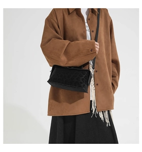 Close-up of a black leopard-textured crossbody bag showing matte embossed pattern details