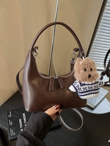 Sac bandoulière rétro marron foncé avec peluche chien dans un décor vintage