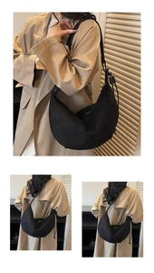 Detail showing soft black suede texture and drawstring strap of the moon crescent bag