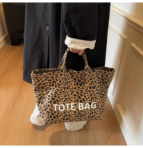 Close-up of leopard print canvas tote bag with white TOTE BAG lettering in modern setting