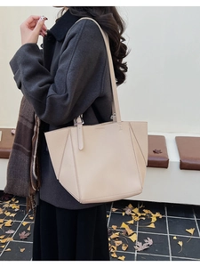 Detail of beige lychee texture tote bag with geometric stitching on gray coat