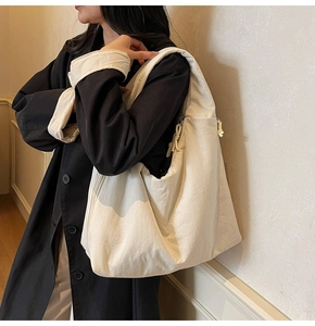 Detail view of large cream canvas tote bag with side drawstring and wide shoulder strap
