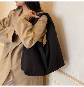 Detail of minimalist black canvas tote bag showing its soft texture and wide shoulder strap