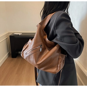 Detail of soft caramel faux leather tote bag with stylish zipper pocket and wide strap