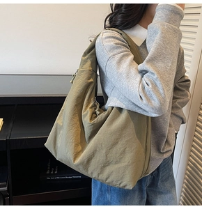 Detail shot of the olive green canvas tote bag showing the wide strap and spacious design