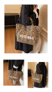 Detail of leopard print canvas tote bag featuring white TOTE BAG text and sturdy handles