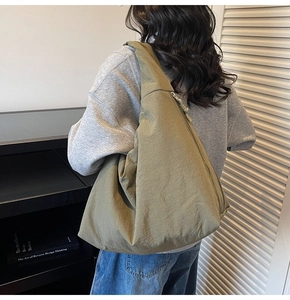 Olive green nylon hobo bag on shoulder showing large capacity and soft texture