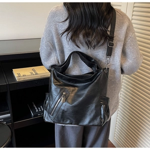 Rear view of large black leather hobo bag showing adjustable strap and draped silhouette