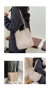 Detail of beige tote bag showing lychee grain leather texture and metal buckle