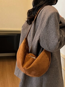 Vintage caramel suede hobo bag shown on model with minimalist grey wool coat