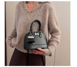 Détail de la texture du sac à main noir vintage avec fermeture éclair et deux poignées
