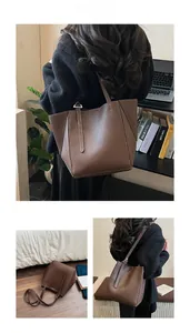 Detail of dark brown tote bag featuring white contrast stitching and lychee grain texture