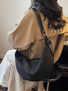Large black suede hobo shoulder bag styled with an elegant khaki trench coat for women