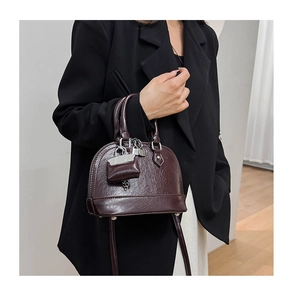 Détail du sac à main rétro en cuir poli avec texture brillante et fermoir métallique