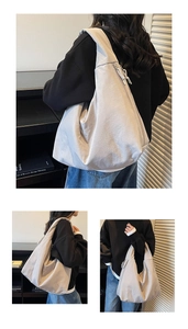Detailed macro view of large nylon tote bag featuring wide shoulder strap and woven drawstrings