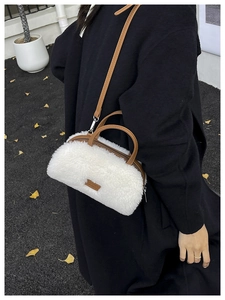 Winter white faux fur crossbody bag with brown leather straps worn with black coat