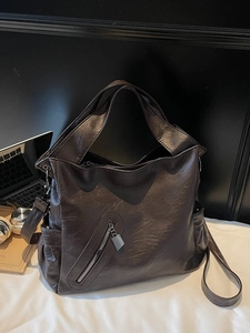 Large dark brown vintage leather tote bag with side pockets and crossbody strap for commuting