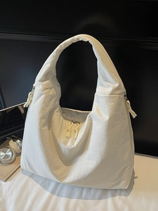 Minimalist white nylon crescent tote bag with textured finish and knot zipper detail