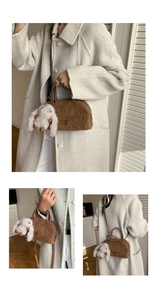 Detail view of brown plush crossbody bag with leather strap and white rabbit pendant