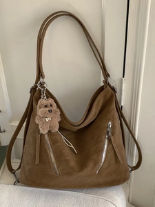 Brown vintage Hobo tote bag with decorative zippers and a plush puppy keychain accessory