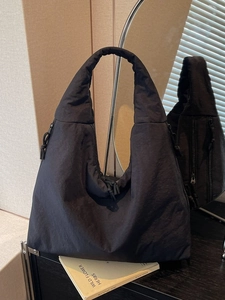 Solid black quilted nylon tote bag with crescent shape and large capacity for women