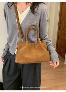 Brown faux suede baguette bag with round handles and strap in a minimalist retro style