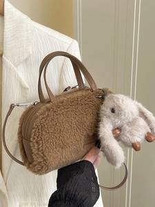 Brown faux fur cylindrical handbag with a cute plush rabbit pendant and leather strap
