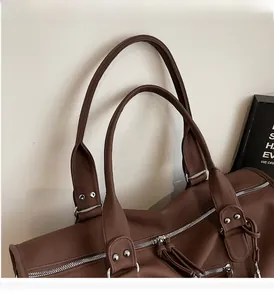 Detailed close-up of dark brown lychee grain leather handbag with silver rivets