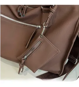 Close-up of coffee brown tote featuring litchi grain leather and a detachable mini pouch