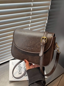 Minimalist dark brown leather crossbody bag with adjustable strap and vintage brass hardware