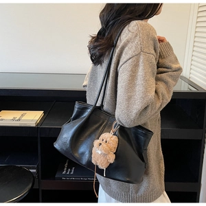 Détail du grand sac cabas en cuir souple noir avec charmant petit pendentif chien en peluche