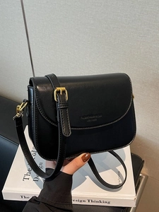 Minimalist black leather crossbody bag with adjustable gold hardware and fashion lettering