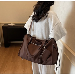 Detail of dark brown large travel bag with detachable pouch and wide shoulder strap