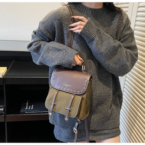 Detail of vintage patchwork backpack with olive green body and brown leather flap contrast