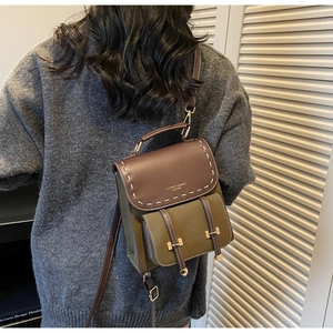Detail of vintage olive green backpack with contrast stitching and golden hardware