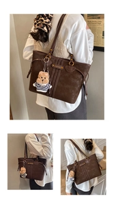 Detailed view of the dark brown retro tote bag with badge and plush bear charm