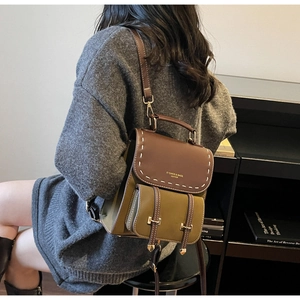 Detail view of vintage contrast leather backpack with stitching and metal buckle